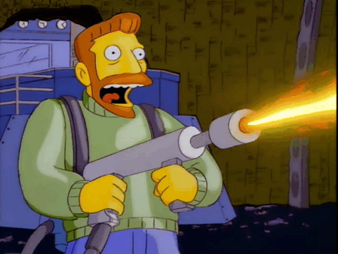 Hank Scorpio from The Simpsons laughs while using a flamethrower