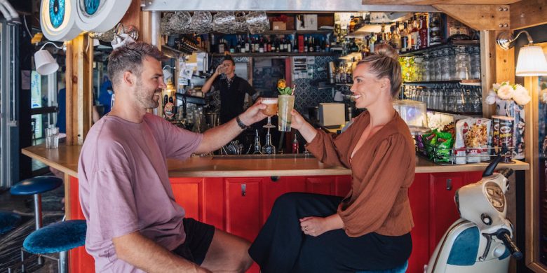 A man and a woman cheersing in Babylon Bar in Darwin